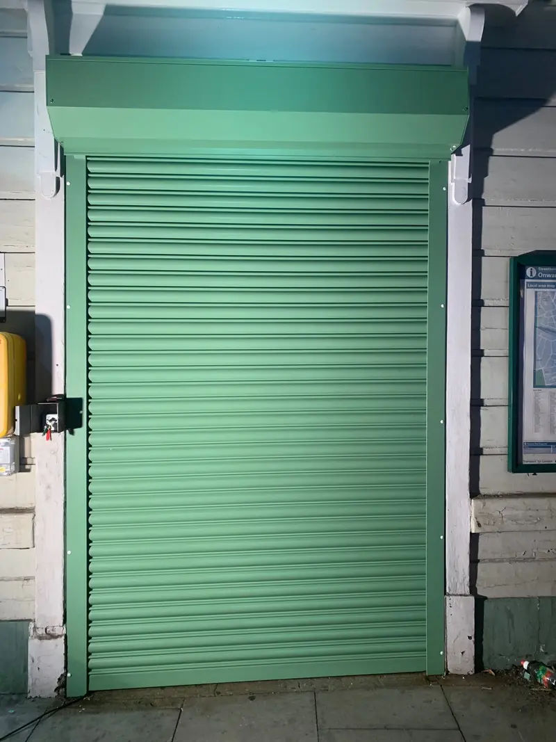 a green roller shutter closed across the entrance.